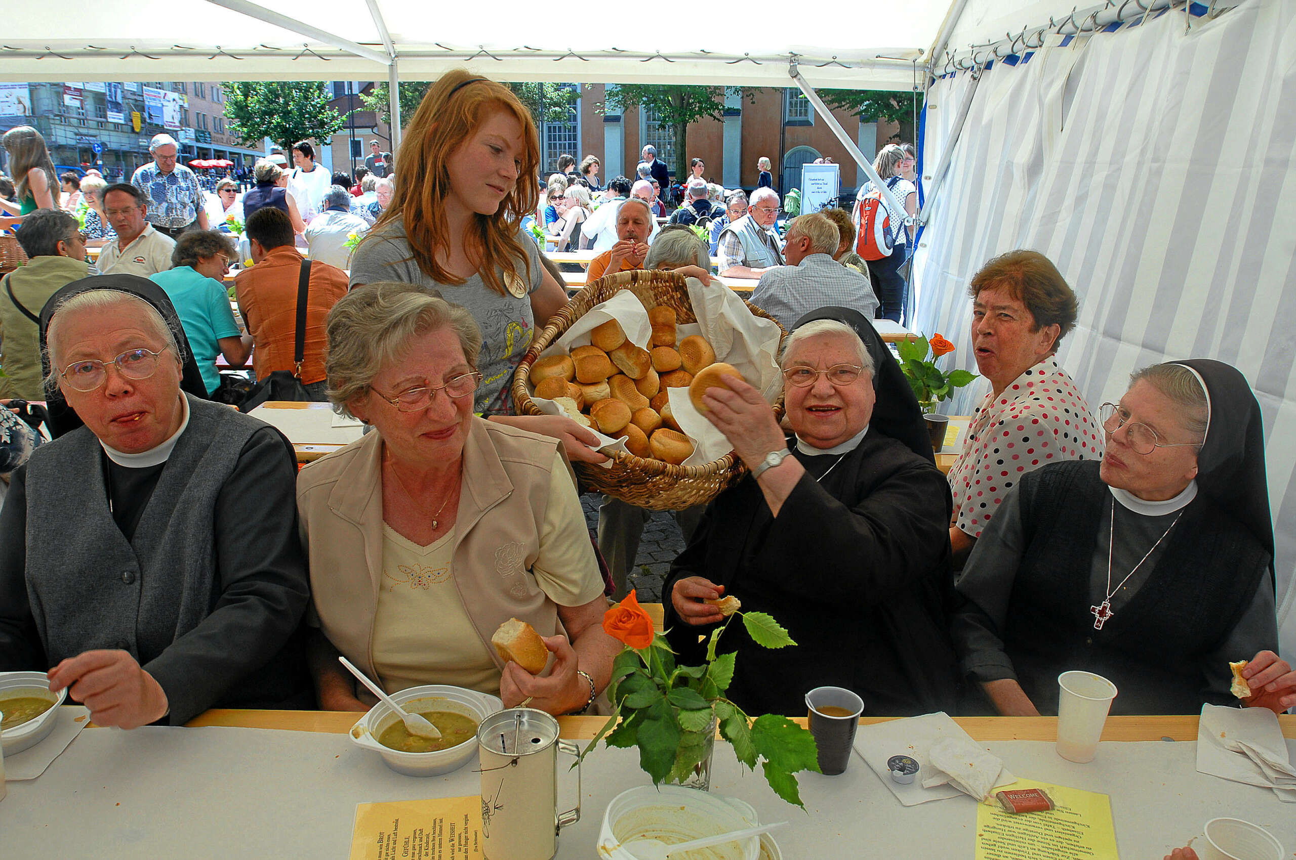 © Foto: Norman Meißner
Elisabethtafel auf dem Eisenacher Marktplatz
Organisiert durch die evangelische und katholische Kirchgemeinde, die Caritas Regionalstelle Eisenach, den Diakonie-Verbund Eisenach die Diakonissenhaus-Stiftung und die Johaniter Unfallhilfe

Die Erbsensuppe schmeckte vorzüglich.
Laura Sturm aus der 8. Klasse des Martin-Luther-Gymnasium verteilt Brötchen an die Franziskanerinnen der Elisabeth-Gemeinde Eisenach