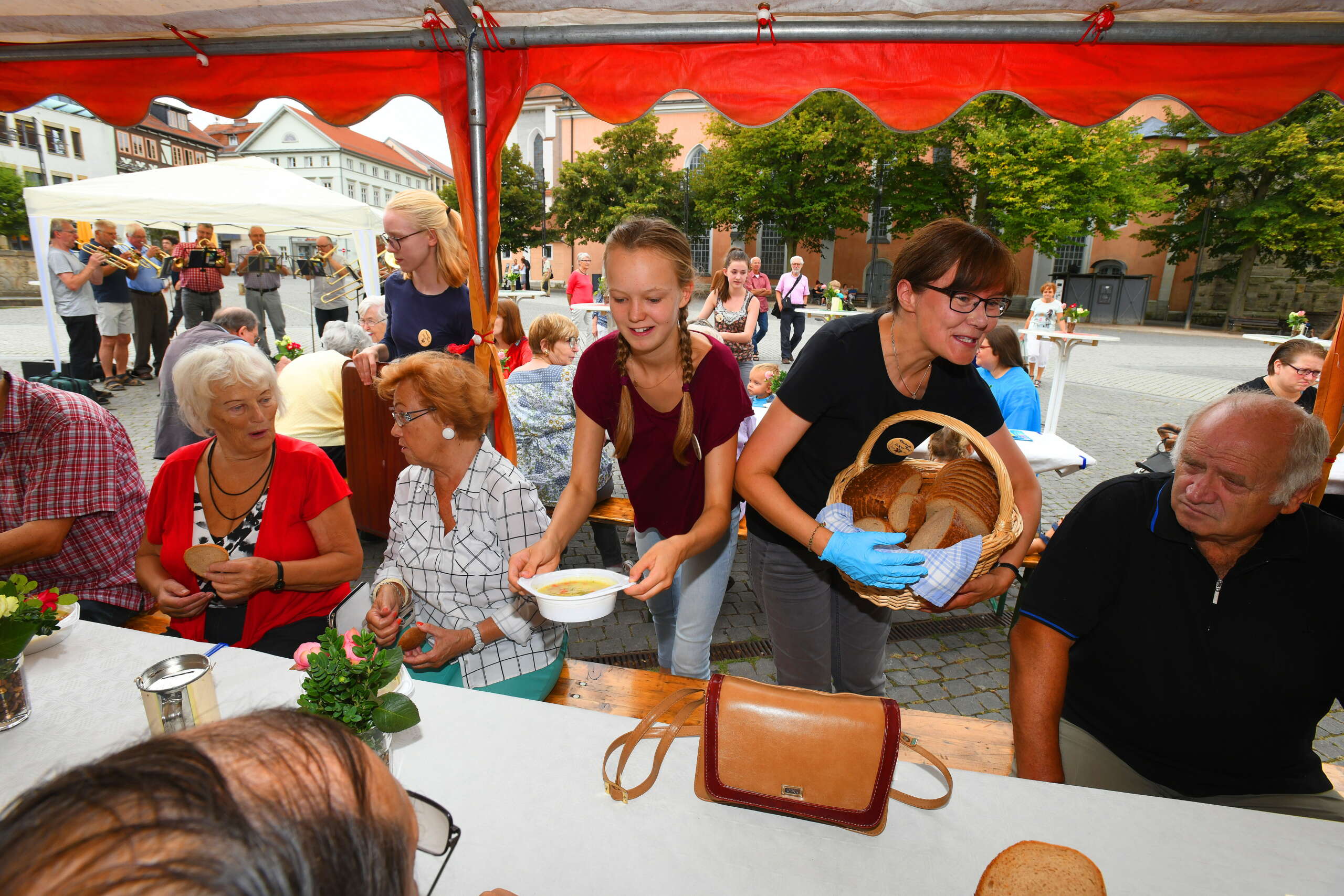 © Foto: Norman Meißner
Elisabethtafel 2018 auf dem Eisenacher Marktplatz
Organisiert durch die evangelische und katholische Kirchgemeinde, die Caritas Regionalstelle Eisenach, den Diako Diakonie-Verbund Eisenach  und die Johanniter

auf dem Foto:
die Gäste an der Tafel lassen sich die Gemüsesuppe schmecken.
Almut Iffland von der Caritas schenkt hier Brot aus. Die Schülerinnen vom Luthergymnasiium, Fanny Starke (weinrot)  und Nele Fleischmann (blau), teilen die Suppenteller aus.







Elisabeth-Tafel